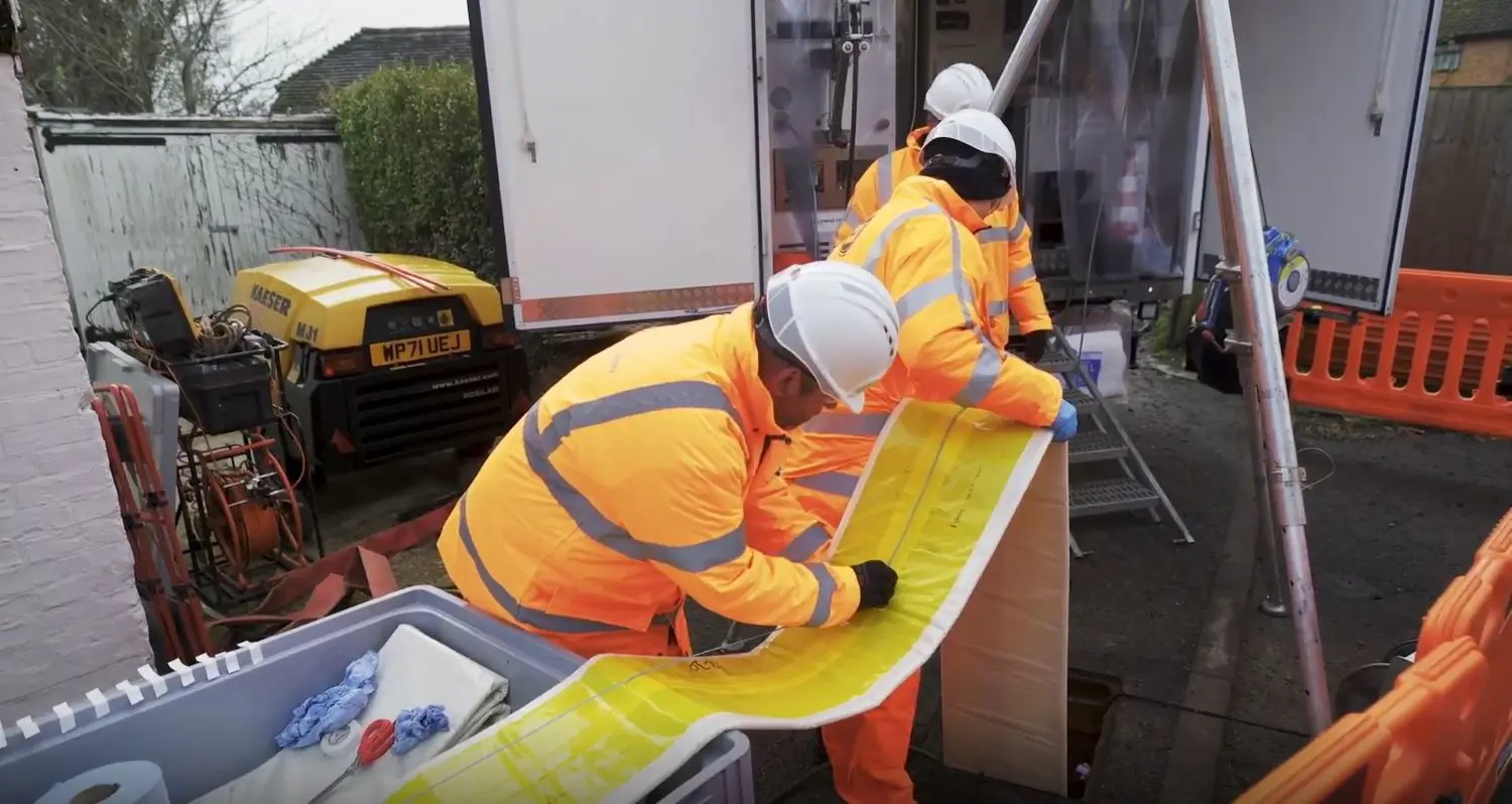 Two men preparing to seal a sewer