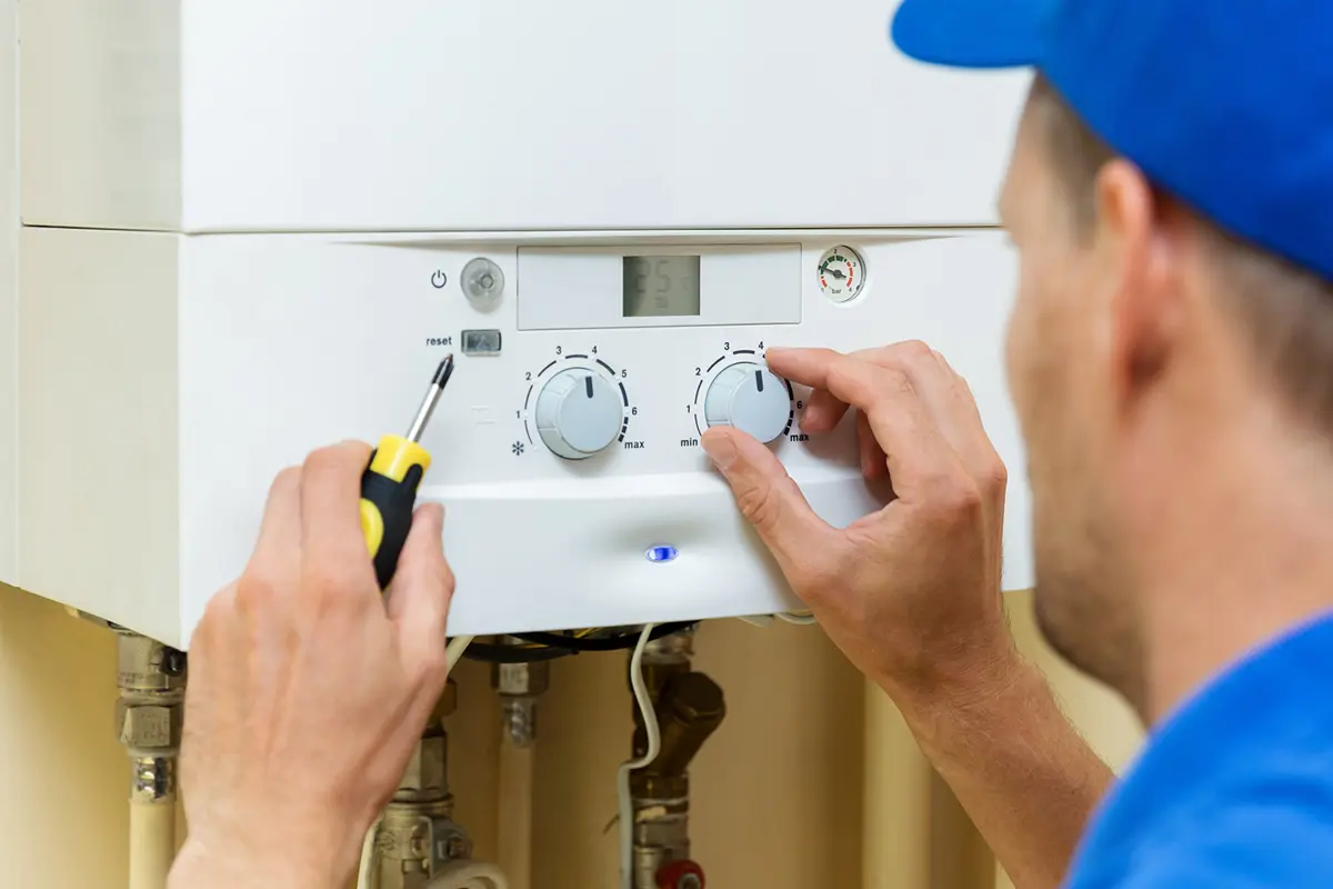 A worker adjusting a boiler