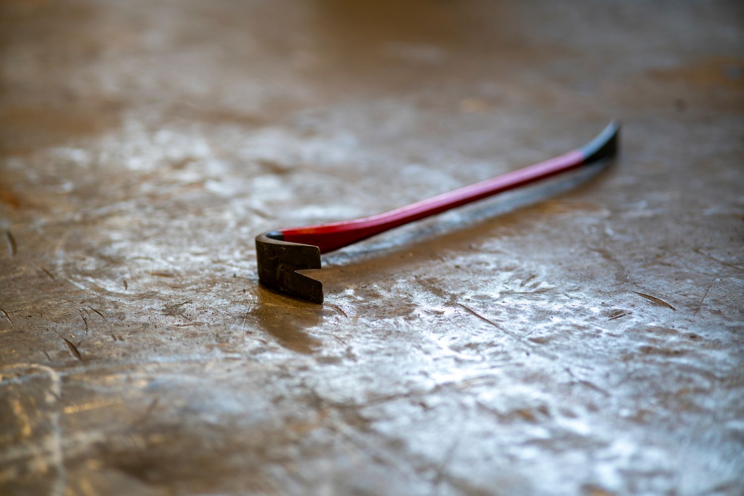 red and black crowbar on the floor