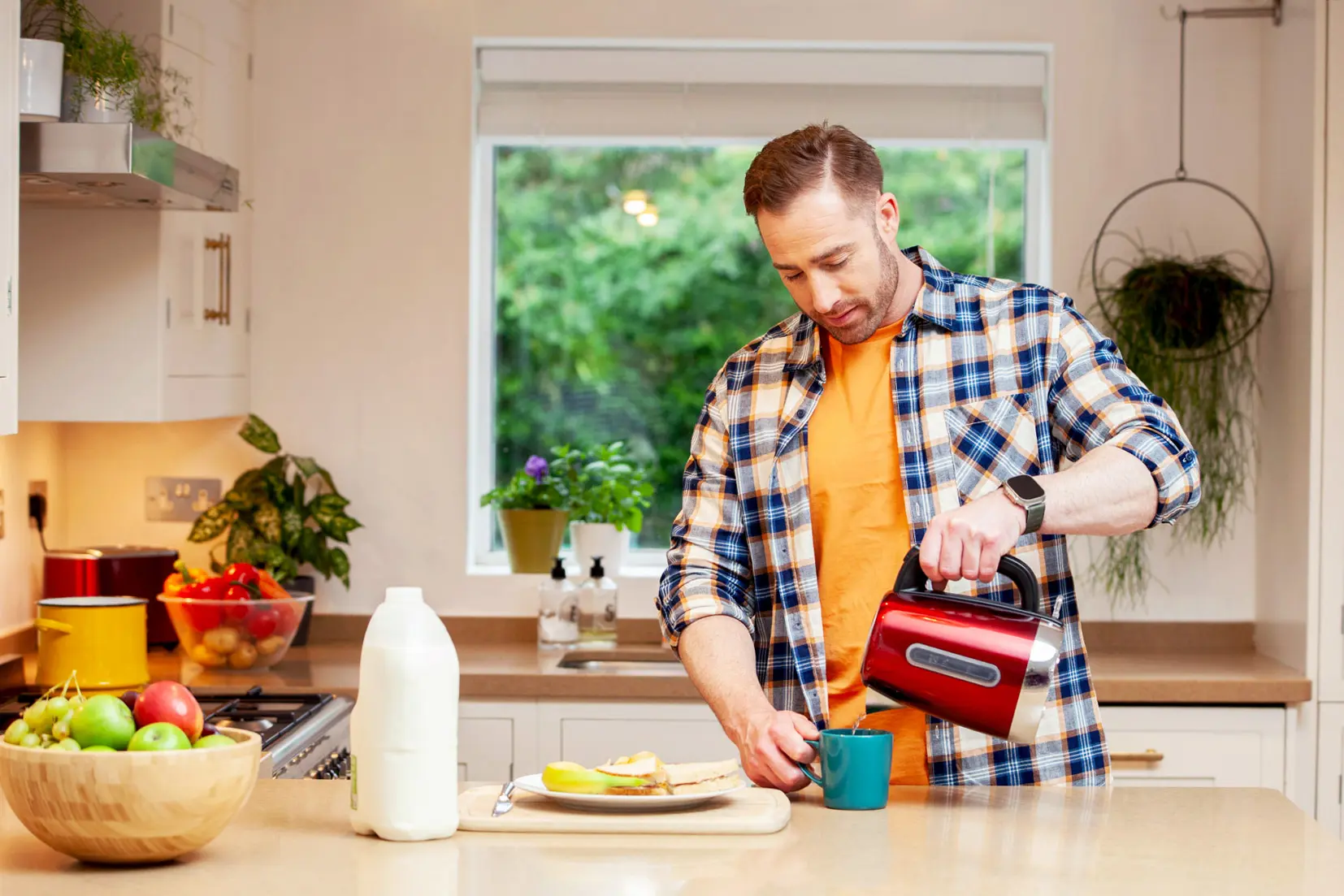 man making a hot drink in his kitchen