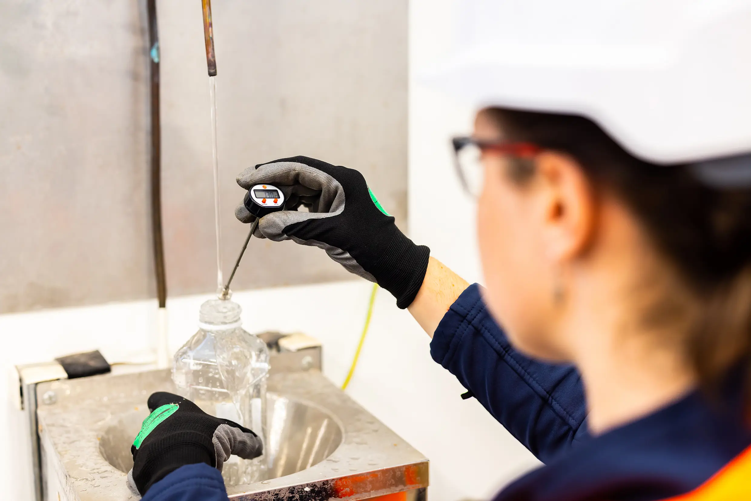 An over the shoulder close up shot of a person examining and testing water